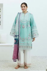  A woman dressed in a mint green embroidered suit, showcasing intricate designs, with a serene expression on her face.