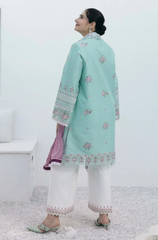 A woman in a stylish mint green suit and white pants, posing gracefully with a plain background.

