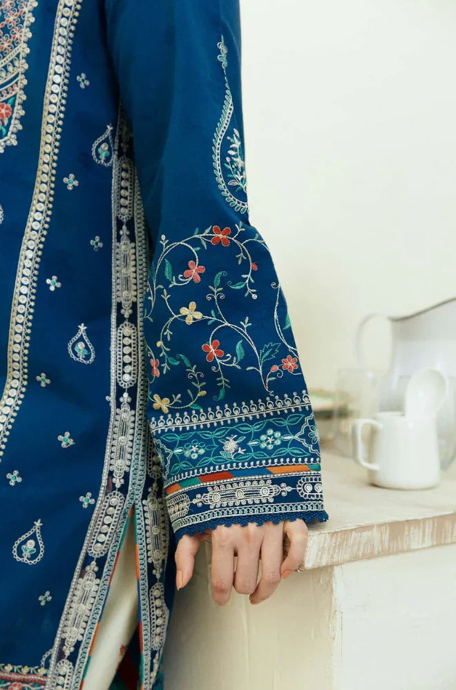  A woman models a blue and white embroidered dress, highlighting its detailed craftsmanship and stylish appearance.